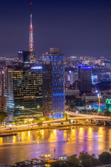 Naklejka premium Aerial view of Bitexco Tower, buildings, roads, Thu Thiem 2 bridge and Saigon river in Ho Chi Minh city - Far away is Landmark 81 skyscraper. Travel concept.