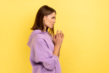 Side view of devious cunning young woman clasping hands and smirking mysteriously, scheming cheats,...