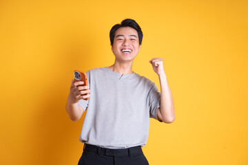 Asian young man posing on a yellow background