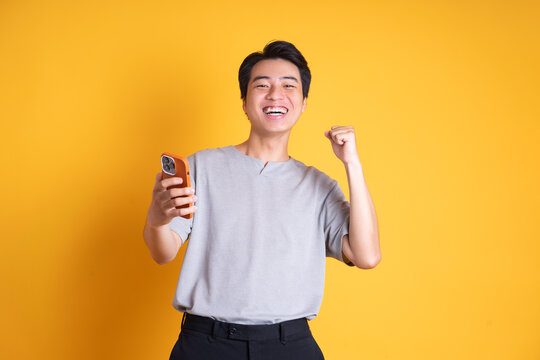 Asian Young Man Posing On A Yellow Background