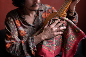 Fototapeta premium A young Mexican musician is cleaning his jarana guitar