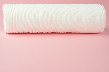 Stacked cotton pads on pink background, copy space.