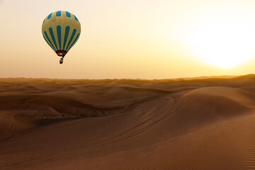 Fototapeta na wymiar Hot air balloon in sand desert sunset landscape, Dubai, United Arab Emirates
