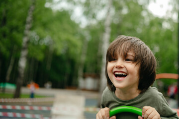 Happy little three years old child riding seesaw with big smile and happy face