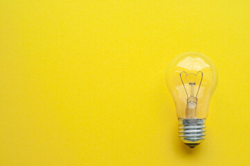 Light bulb isolated, yellow background, symbol of idea
