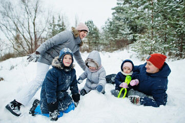 Father and mother with three children in winter nature. Outdoors in snow.