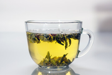 glass cup with green tea reflected in gray glass