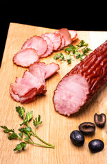 Rustic composition with a smoked, dry Krakowska sausage. Traditional Polish meat cold cuts.
