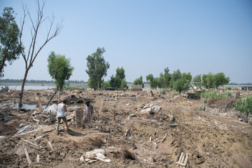 a pile of concrete left by flash flood in Pakistan. People are trying to find their household items