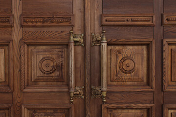 Antique massive wooden doors with large handles close-up. Ancient architecture