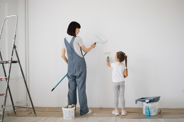 Full length portrait back view of young mother and her small cute daughter enjoying time together...