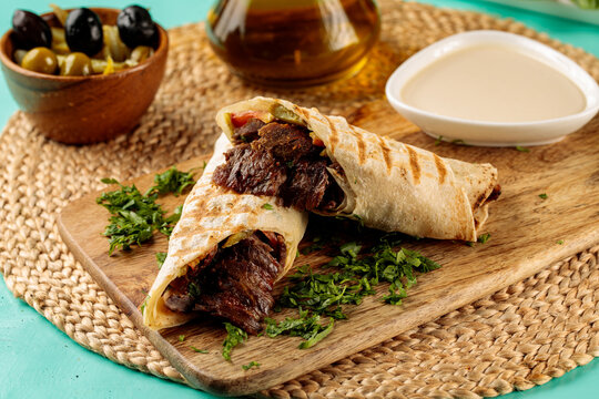 Meat Saj Shawarma wrap roll with mayo dip served in dish isolated on wooden table side view of middle eastern food