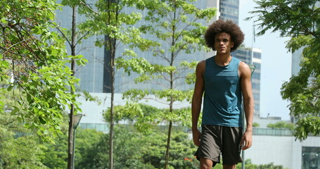 Naklejka na ściany i meble Sportive young black african man walking at park
