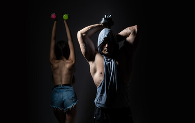 Couple exercising with dumbbells together. Sexy strong fit body. Couple training with dumbbell.