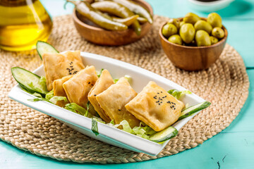 Fried Sambosek Cheese with olive served in dish isolated on wooden table side view of middle eastern food