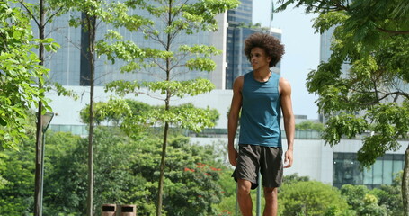 Naklejka na ściany i meble Sportive young black african man walking at park