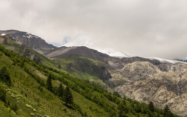 Obraz premium Dramatic mountain slopes with glaciers and sharp peaks in Kabardino-Balkaria of Russia and cloudy dramatic sky