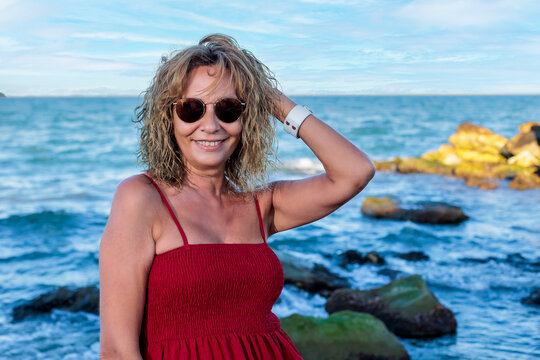 woman over 50 in red on the beach