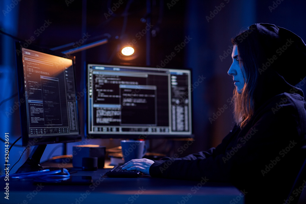 Poster cybercrime, hacking and technology concept - female hacker in dark room writing code or using comput
