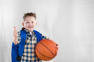 Smiling boy holding a basketball ball and posing