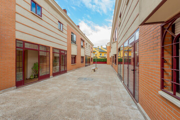 Fototapeta na wymiar passageway between single-family urban residential homes with red aluminum carpentry