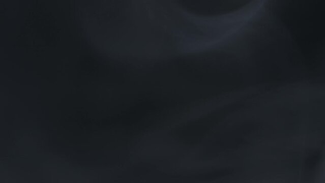 Defocused glow overlay. Mist flow. Steam texture. Logo opener. Blur gray transparent smoke cloud motion on dark black grunge background.