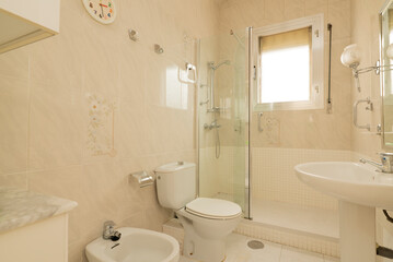 toilet in white tones with square aluminum window, mirror on the wall and shower cabin with glass partition