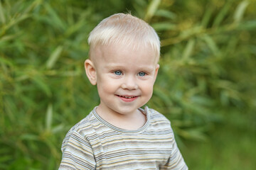 Portrait of smiling toddler boy in striped t-shirt. Close-up. Concept of kindergarten, education