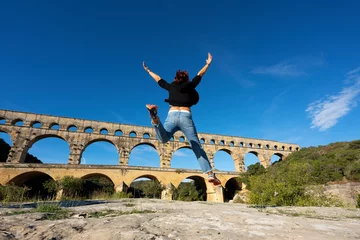 Papier Peint photo autocollant Pont du Gard Vue de femme sautant devant le Pont du Gard