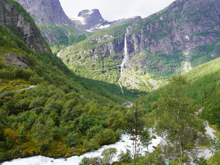 Blick ins Tal mit Wasserfall und hohen Bergen bei der Wandertour zum Briksdalsbreen in Norwegen
