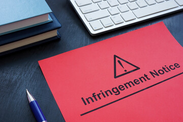 Infringement notice near a keyboard and notepads.