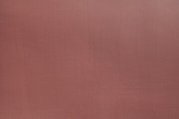 Fototapeta premium Rufous or dark brown wall, texture, background. The building wall, painted with water-based paint of dark-red color. Smooth (flat) surface in ginger color