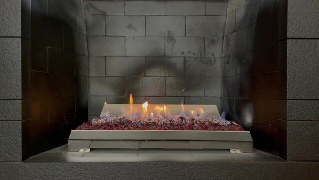 Grey briks fireplace with burning fire