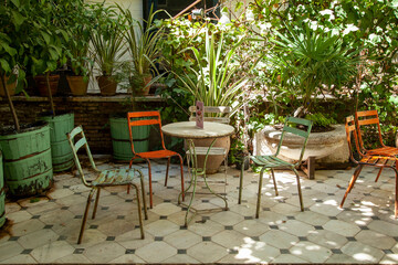 old round metal table in interior patio with plants