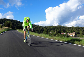Fototapeta premium cyclist with racing bicycle and phosphorescent waterproof jacket on the road