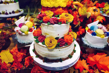 Obraz na płótnie Canvas Beautiful delicious autumn theme cakes and desserts with maple leaves decorations