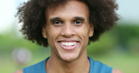 Young handsome mixed ethnicity man closing eyes taking deep breath and smiling laughing outside