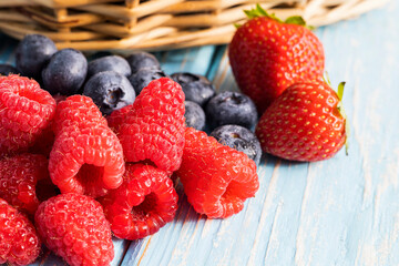Berries on a wooden background. Summer or spring Organic berry. Strawberries, Raspberries, Blueberries. Agriculture, Gardening, Harvesting Concept.