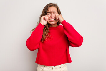 Young caucasian woman isolated on blue background whining and crying disconsolately.