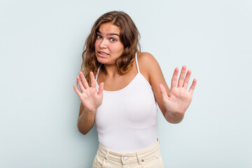 Young caucasian woman isolated on blue background rejecting someone showing a gesture of disgust.