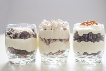 Delicious sweet dessert with cream in a glass on a light background, a beautiful breakfast