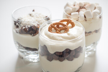 Delicious sweet dessert with cream in a glass on a light background, a beautiful breakfast