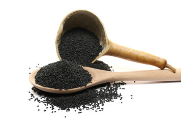 Black sesame seeds pile in wooden spoon isolated on white  