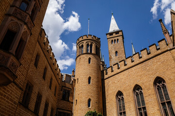 Fototapeta na wymiar Burg Hohenzollern, Baden-Wurttemberg, Germany, 5 July 2022: medieval knights castle with towers in English Gothic Revival architecture, monument to Romanticism, old fortifications on hill at sunny day