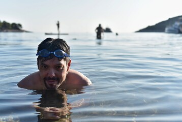 Portrait of a wet man with swimming goggles. A man swam in the sea. Island Mljet in Croatia