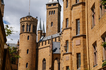 Burg Hohenzollern, Baden-Wurttemberg, Germany, 5 July 2022: medieval knights castle with towers in English Gothic Revival architecture, monument to Romanticism, old fortifications on hill at sunny day