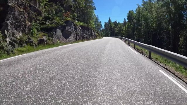 First person view of a nordic road, Norway, lush green contryside