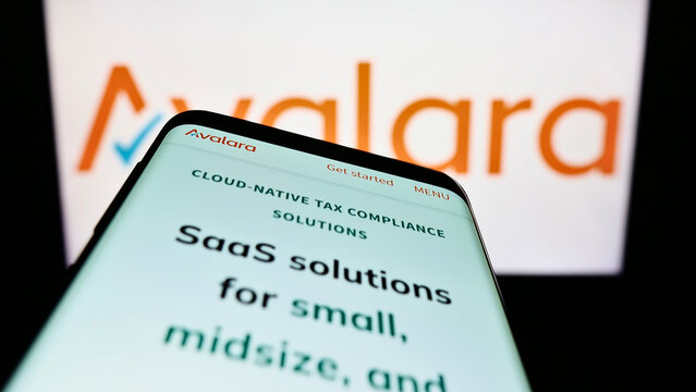 Stuttgart, Germany - 09-08-2022: Mobile phone with webpage of US software company Avalara Inc. on screen in front of business logo. Focus on top-left of phone display.