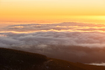 sunset over the clouds in the mountains