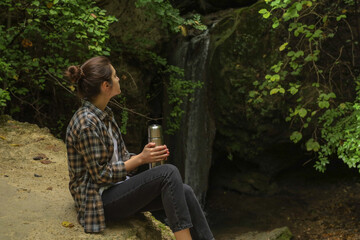 Fototapeta premium girl in the forest with a thermos